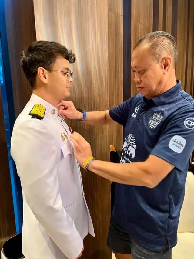 เนวิน ชิดชอบ กำลังจัดเสื้อให้ ไชยชนก ผู้เป็นบุตรชาย