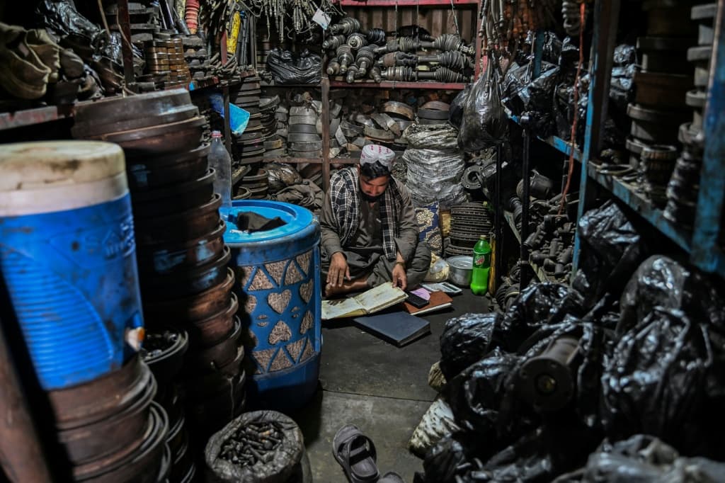 In the dark workshops where cars would usually be built, men sat around while tools and wheels were idle