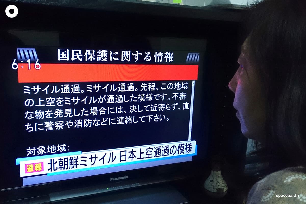 หญิงคนหนึ่งกำลังดูข่าวทางโทรทัศน์ที่แสดงข้อความแจ้งเตือนผ่านระบบ J-Alert ในกรุงโตเกียว เมื่อวันที่ 29 สิงหาคม 2017 หลังเกาหลีเหนือทดสอบขีปนาวุธโดยวิถีการบินพาดผ่านน่านฟ้าญี่ปุ่น (Photo by Kazuhiro NOGI / AFP)