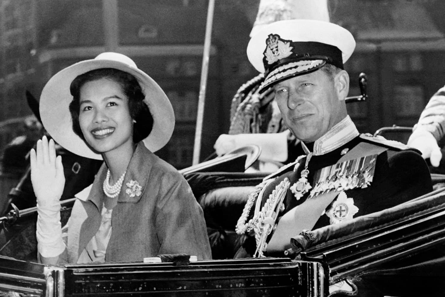 PhotoStory- สมเด็จพระนางเจ้าสิริกิติ์ พระบรมราชินีนาถ พระบรมราชชนนีพันปีหลวง ทรงแย้มพระสรวลขณะทรงโบกพระหัตถ์ร่วมกับเจ้าชายฟิลิป ดยุกแห่งเอดินบะระ ในเดือนกรกฎาคม 1960 (Photo by CENTRAL PRESS / AFP)