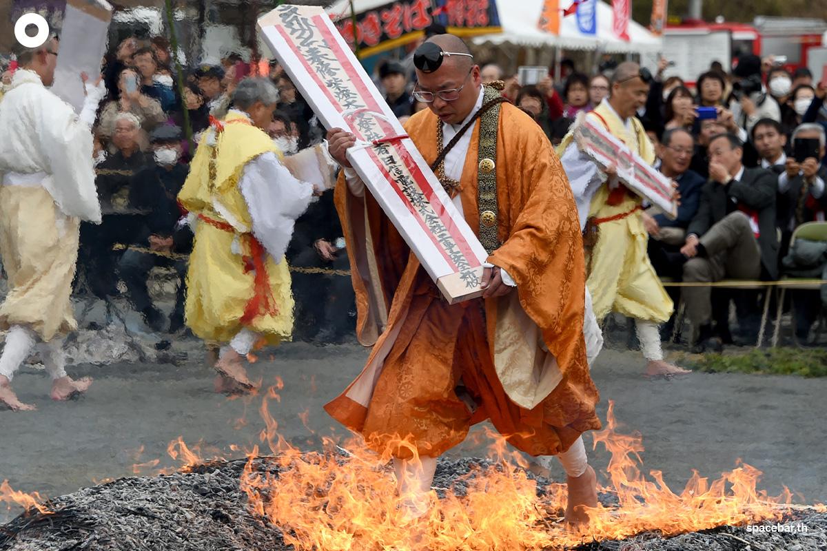 นักบวชในศาสนาพุทธนิกายหนึ่งถือเครื่องรางและเดินเท้าเปล่าลุยไฟในพิธีลุยไฟเพื่อต้อนรับฤดูใบไม้ผลิ Photo by TOSHIFUMI KITAMURA / AFP 