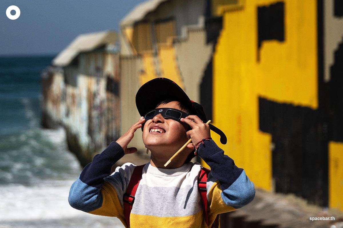 เด็กชายคนหนึ่งสวมแว่นกันแดดแบบพิเศษเพื่อชมสุริยุปราคาบางส่วนในเมืองปลายาส เด ติฮัวนา รัฐบาฮากาลิฟอร์เนีย ประเทศเม็กซิโก เมื่อวันที่ 8 เมษายน 2024 ตามเวลาท้องถิ่น (Photo by Guillermo Arias / AFP)